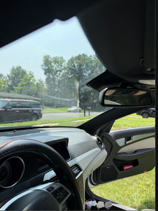 Vehicle cabin view showing a discreetly positioned front dash camera