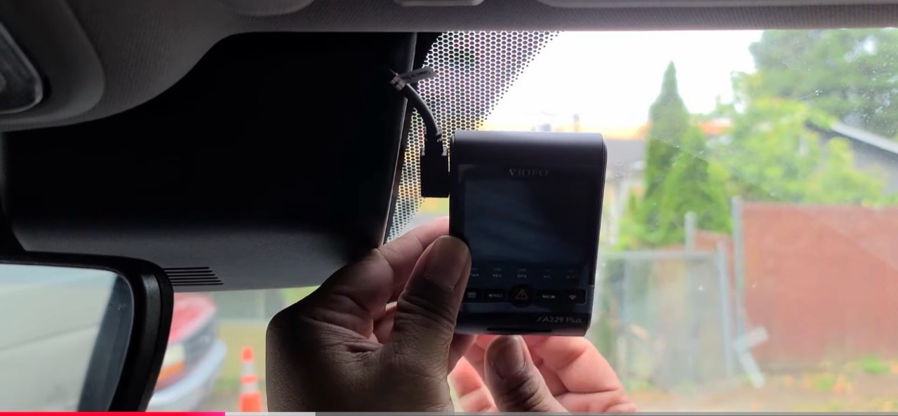 Hands adjusting a VIOFO A229 Plus beside the mirror housing
