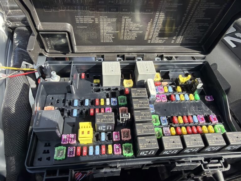 Open engine-bay fuse box in the 2026 Dodge Durango, with blade fuses, relays and the cover diagram visible.